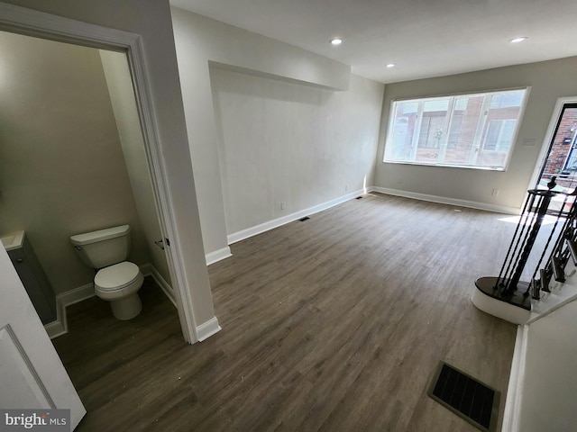 interior space featuring baseboards, plenty of natural light, visible vents, and dark wood-style floors