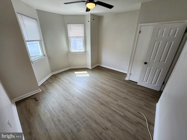 unfurnished bedroom with ceiling fan, baseboards, and wood finished floors
