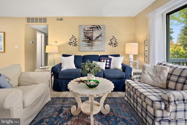 living area with visible vents, wood finished floors, and a wealth of natural light