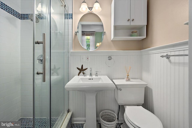 full bath with wainscoting, toilet, and a shower stall