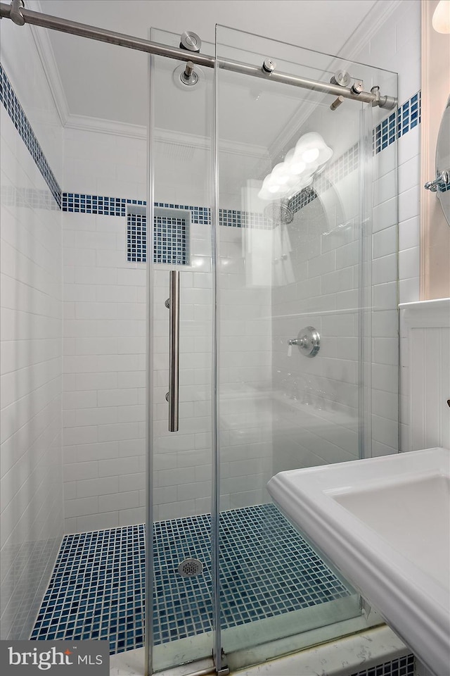 full bath with crown molding and a shower stall