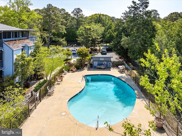 community pool with a patio and fence
