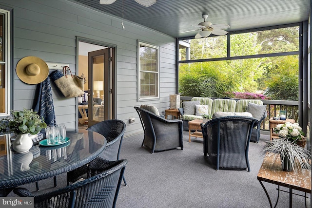 sunroom featuring ceiling fan and an outdoor living space