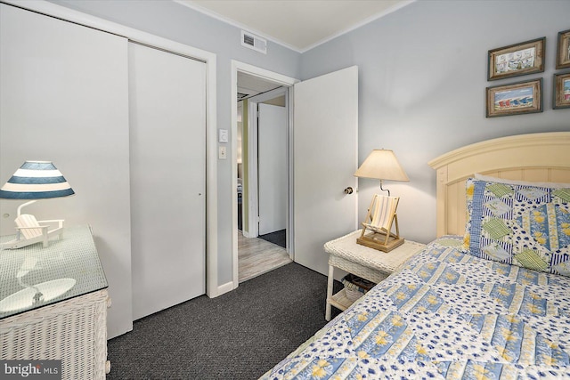 carpeted bedroom with visible vents, ornamental molding, and a closet