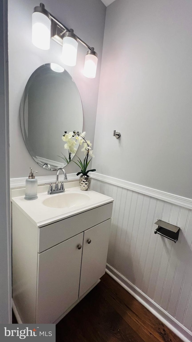 bathroom featuring wainscoting, wood finished floors, and vanity
