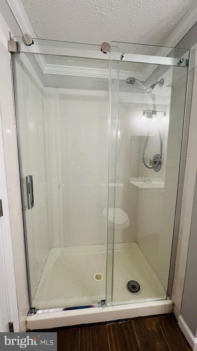 10310 Bridgetown Pl Unit 56, Burke, VA 22015 - full bathroom featuring a textured ceiling, a shower stall, wood finished floors, and ornamental molding