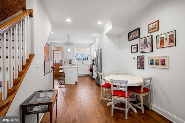 dining room with dark wood-style flooring, stairs, baseboards, ornamental molding, and recessed lighting