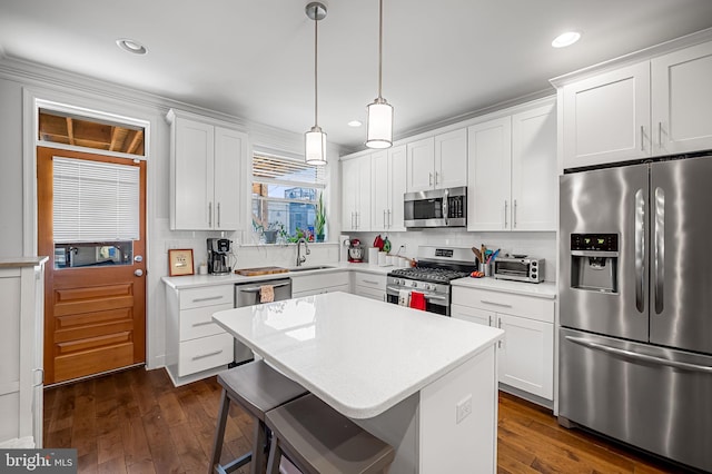 kitchen featuring light countertops, a sink, appliances with stainless steel finishes, and tasteful backsplash