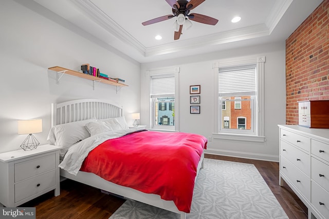 bedroom with a tray ceiling, recessed lighting, dark wood-type flooring, and crown molding