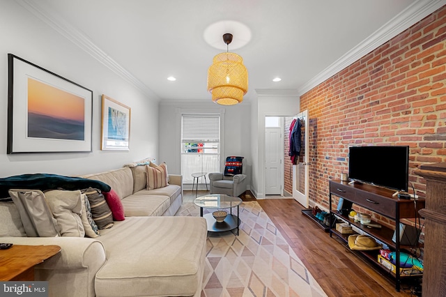 living room featuring recessed lighting, wood finished floors, ornamental molding, baseboards, and brick wall