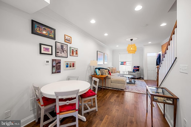 dining area with recessed lighting, dark wood-type flooring, crown molding, baseboards, and stairs