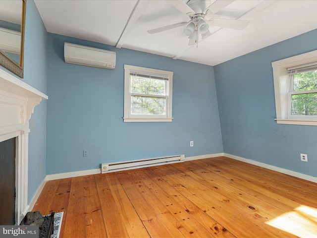 unfurnished living room featuring a wall unit AC, a ceiling fan, baseboard heating, hardwood / wood-style flooring, and baseboards