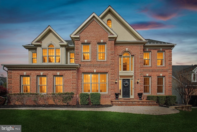 view of front of property with a yard and brick siding