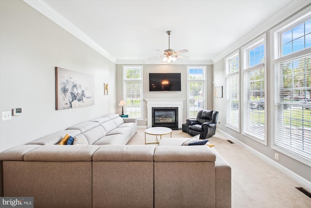 living room with ornamental molding, baseboards, carpet floors, and a glass covered fireplace