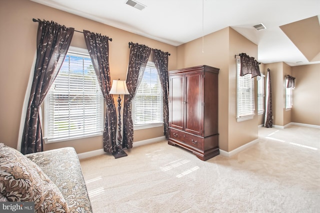 living area with light colored carpet, visible vents, and baseboards