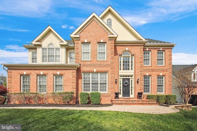 view of front of home featuring a front yard and brick siding