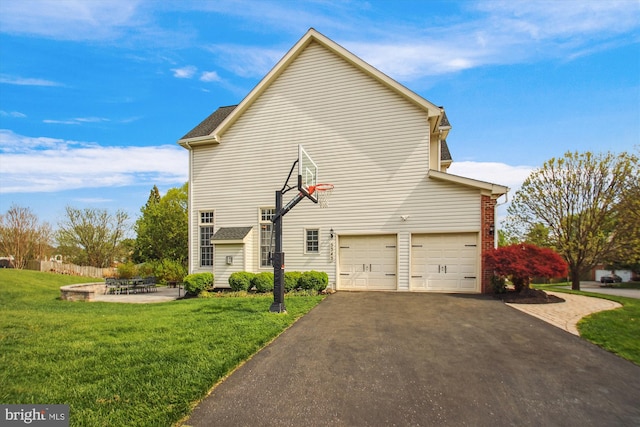 view of side of home featuring driveway, an attached garage, and a lawn