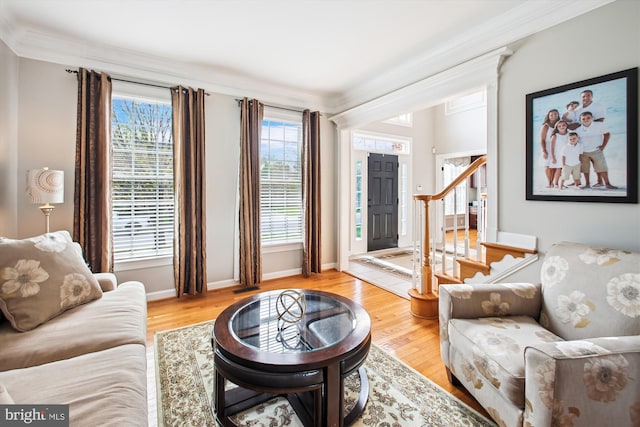living area featuring ornamental molding, stairs, and wood finished floors