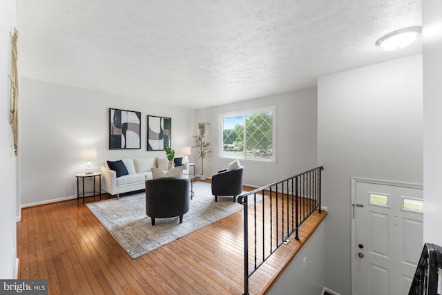 2116 Bell Tree Ln, Waldorf, MD 20601 - living room with hardwood / wood-style floors, baseboards, and a textured ceiling