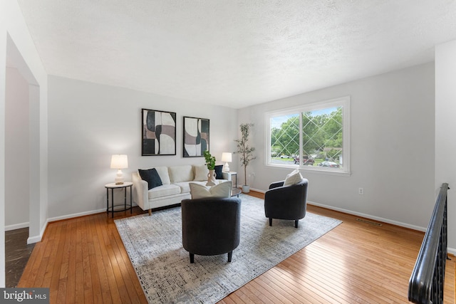2116 Bell Tree Ln, Waldorf, MD 20601 - living room featuring hardwood / wood-style floors, baseboards, and a textured ceiling