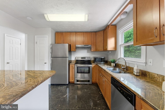2116 Bell Tree Ln, Waldorf, MD 20601 - kitchen with appliances with stainless steel finishes, a sink, under cabinet range hood, brown cabinetry, and stone counters