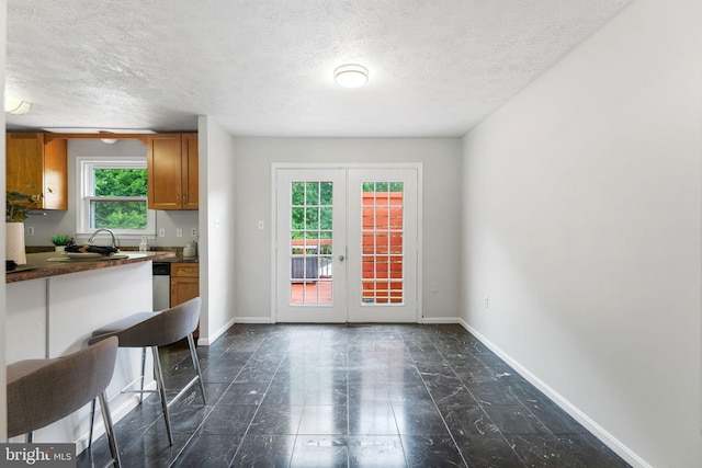 2116 Bell Tree Ln, Waldorf, MD 20601 - kitchen with dark countertops, brown cabinetry, a textured ceiling, baseboards, and french doors