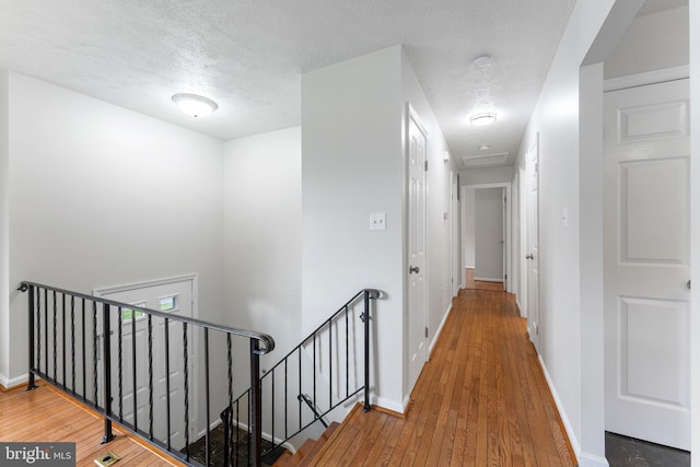 2116 Bell Tree Ln, Waldorf, MD 20601 - hallway featuring an upstairs landing, hardwood / wood-style floors, a textured ceiling, and baseboards