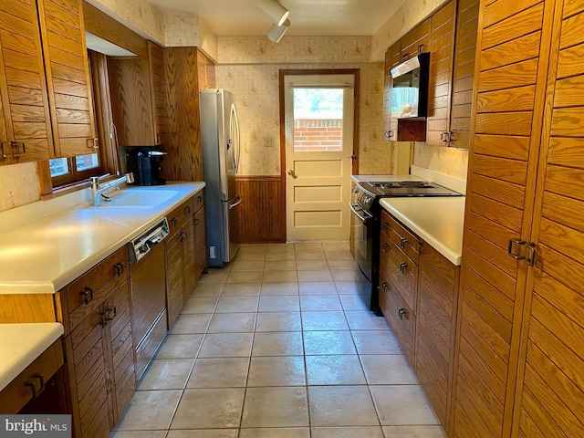 490 Orlando Ave, State College, PA 16803 - kitchen with appliances with stainless steel finishes, a sink, wooden walls, light countertops, and brown cabinets