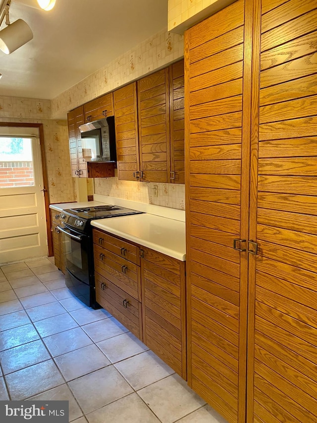 490 Orlando Ave, State College, PA 16803 - kitchen with black / electric stove, brown cabinetry, light tile patterned floors, and light countertops