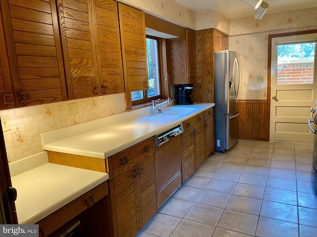 490 Orlando Ave, State College, PA 16803 - kitchen featuring dishwashing machine, stainless steel fridge with ice dispenser, a sink, wood walls, and plenty of natural light