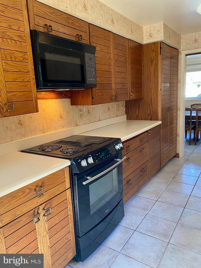 490 Orlando Ave, State College, PA 16803 - kitchen with black appliances, brown cabinets, light tile patterned flooring, and light countertops