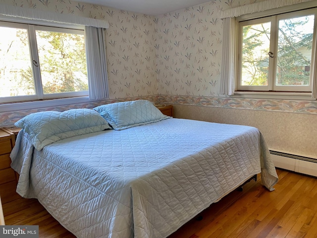 490 Orlando Ave, State College, PA 16803 - bedroom featuring wallpapered walls, wood finished floors, wainscoting, and baseboard heating
