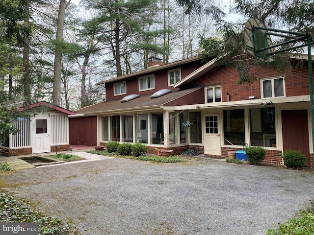 490 Orlando Ave, State College, PA 16803 - view of front facade featuring a chimney, brick siding, an outbuilding, and a sunroom