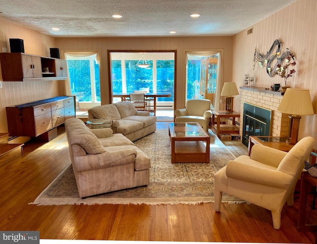 490 Orlando Ave, State College, PA 16803 - living area with a textured ceiling, hardwood / wood-style flooring, and a brick fireplace