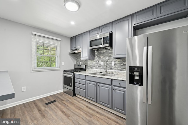 1943 Brookside Dr, Edgewood, MD 21040 - kitchen with a sink, backsplash, gray cabinets, under cabinet range hood, and appliances with stainless steel finishes