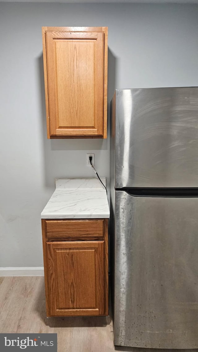 8671 Greenbelt Rd Unit 101, Greenbelt, MD 20770 - kitchen with freestanding refrigerator, wood finished floors, and baseboards