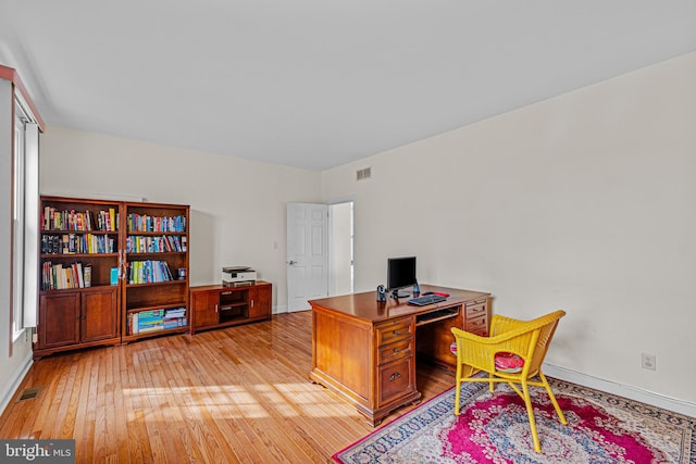 office featuring light wood-type flooring, baseboards, and visible vents