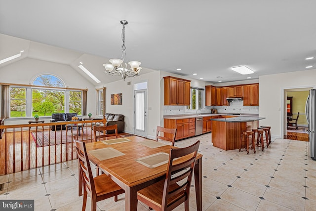 dining area with an inviting chandelier, light tile patterned flooring, vaulted ceiling, and recessed lighting