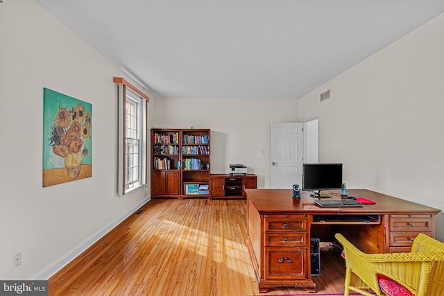 office area featuring light wood-type flooring, visible vents, and baseboards