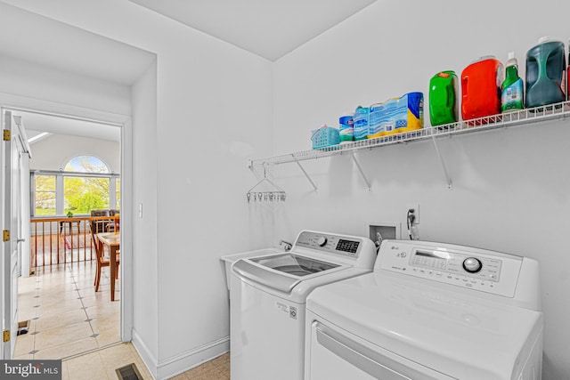 clothes washing area featuring visible vents, baseboards, washer and dryer, and laundry area