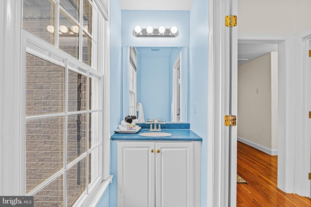 bathroom featuring wood finished floors, vanity, and baseboards