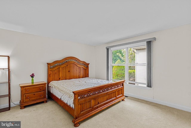 bedroom featuring light colored carpet and baseboards