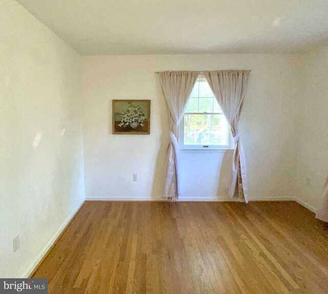 empty room featuring baseboards and wood finished floors