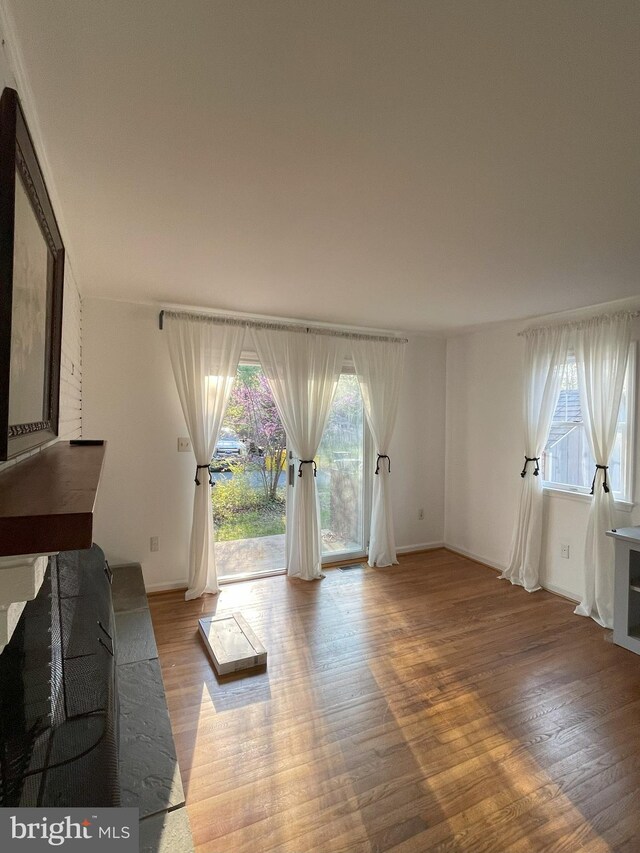unfurnished living room with light wood-style floors and baseboards