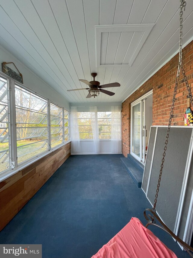 unfurnished sunroom with a ceiling fan