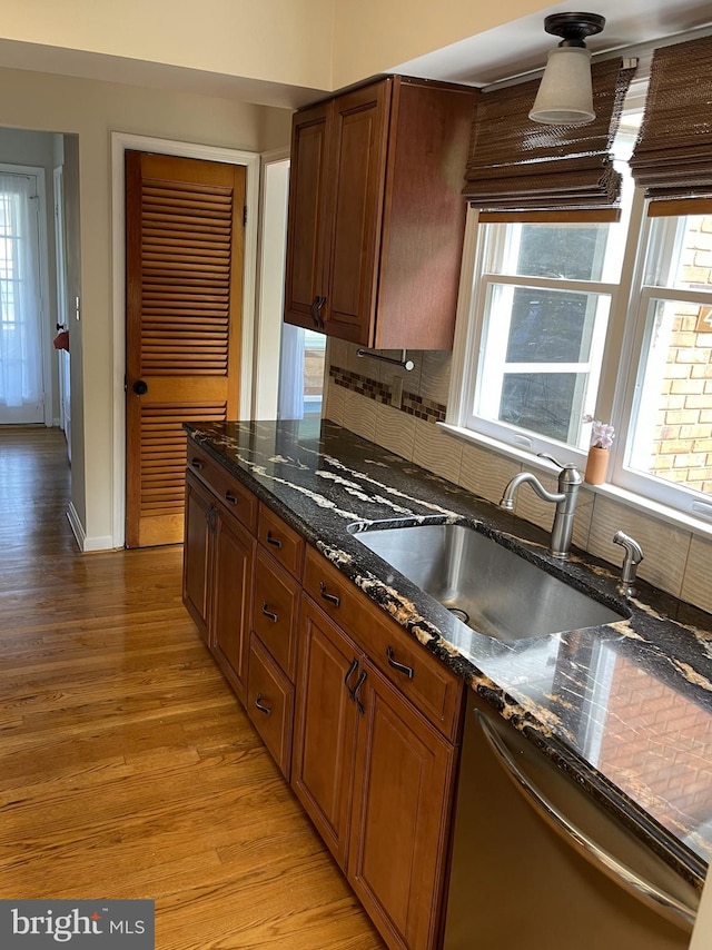 kitchen featuring a wealth of natural light, light wood-style flooring, a sink, and dishwasher