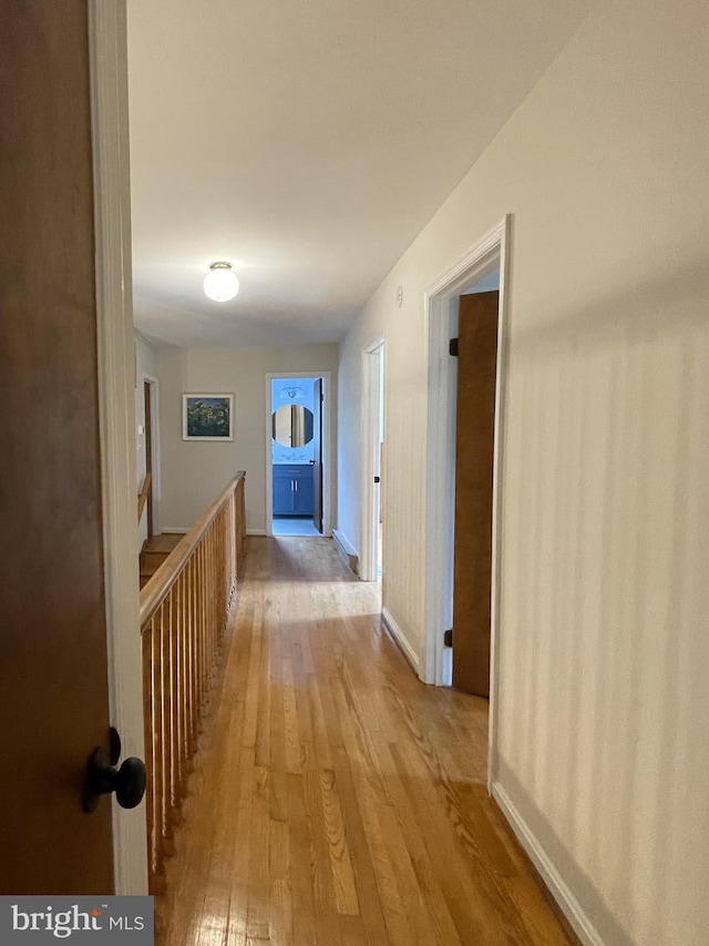 hallway featuring baseboards and light wood-style flooring