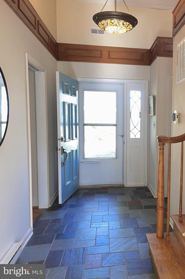 foyer featuring visible vents, stone tile floors, and baseboards