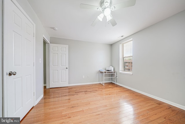 unfurnished bedroom with baseboards, a ceiling fan, and light wood-style floors