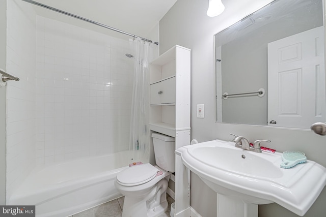 bathroom featuring tile patterned floors, shower / tub combo with curtain, a sink, and toilet